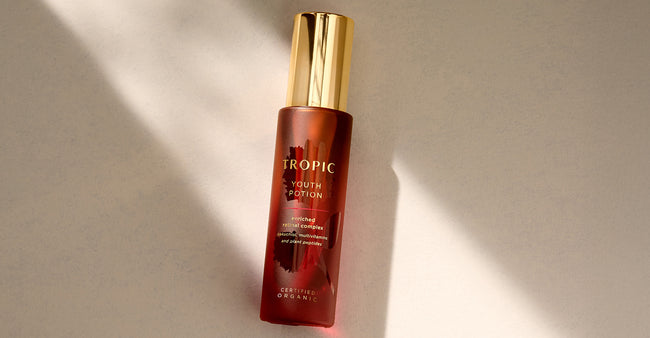 Tropic Youth Potion bottle with a gold cap, containing enriched retinal complex with bakuchiol, multivitamins, and plant peptides, displayed on a neutral background.